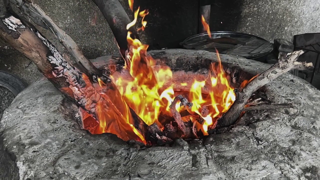 在火炉里烧柴。准备煮肉的炉膛。在户外烧烤。视频素材