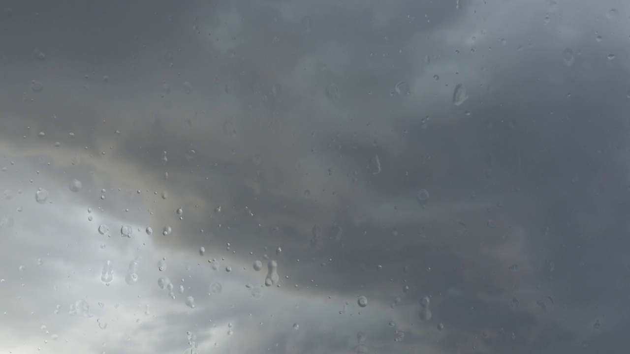 雨滴顺着玻璃流下来。大气环流是地球表面的一系列气流。灰色的云。积云云景慢动作。秋天或冬天。自然天气预报。视频素材