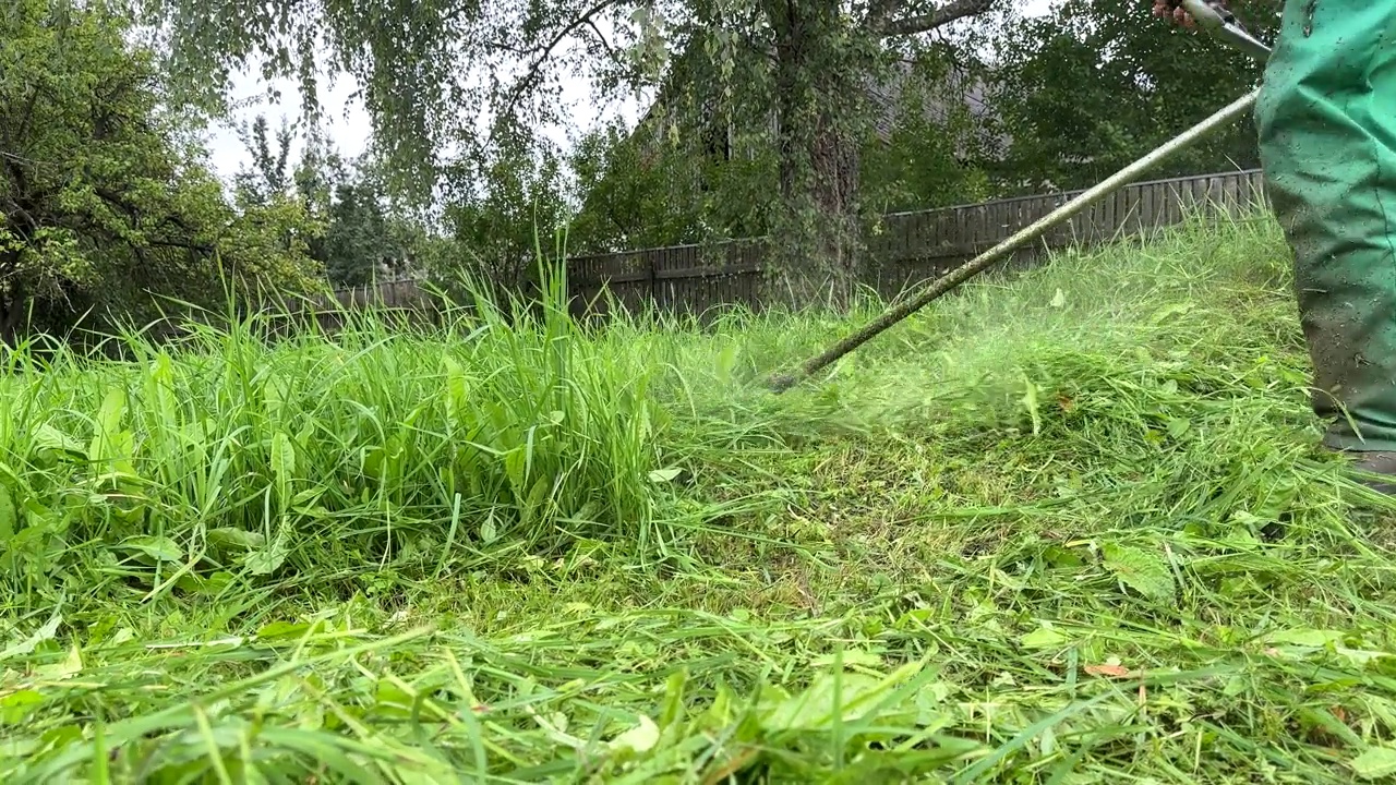 园丁修剪杂草。剪草机和割草机。草坪养护服务。视频素材