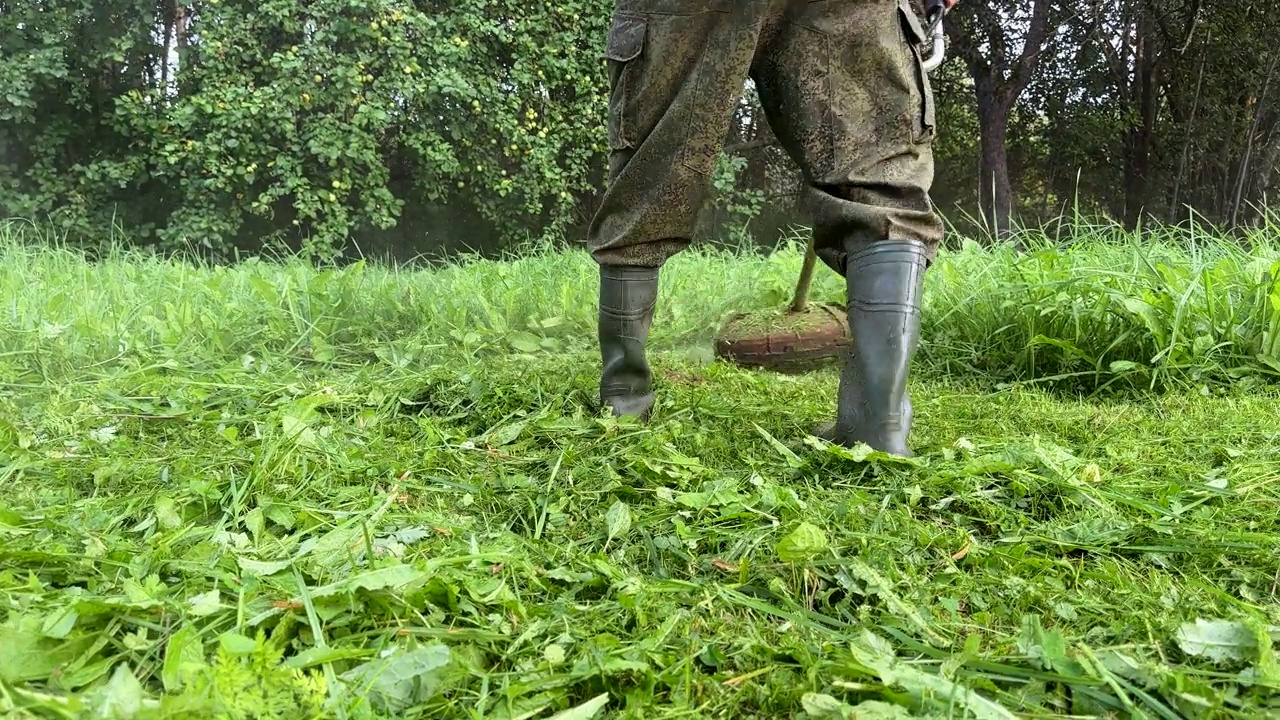 园丁修剪杂草。剪草机和割草机。草坪养护服务。视频素材