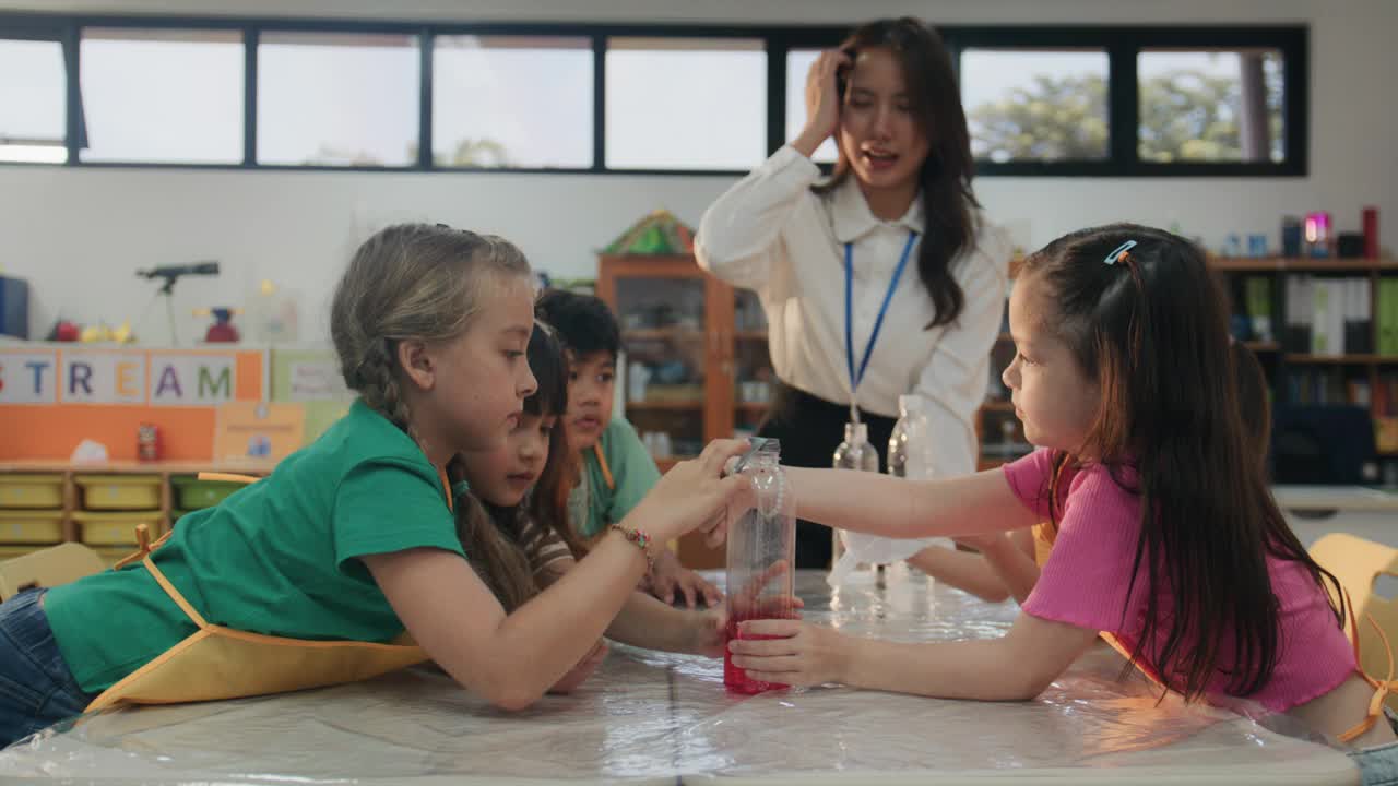 不同的小学生在学校的课堂上对科学实验充满了乐趣和兴奋。视频素材