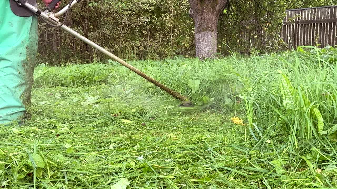 园丁修剪杂草。剪草机和割草机。草坪养护服务。视频素材