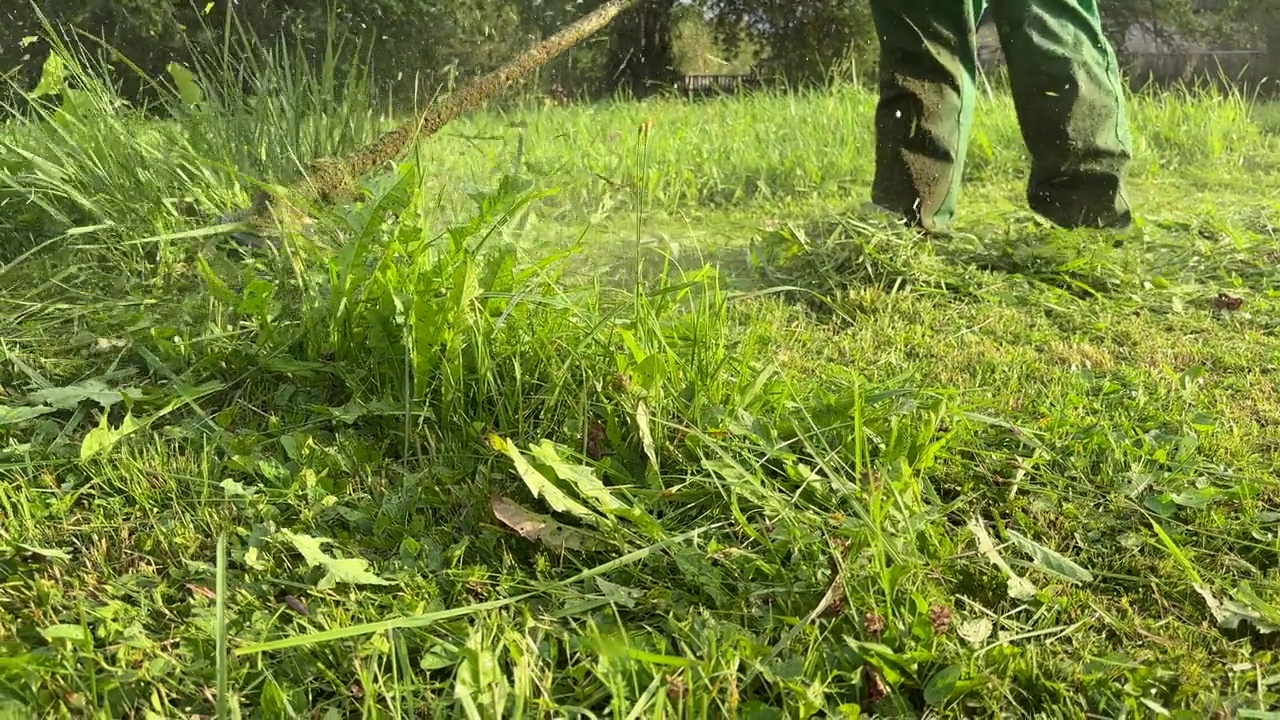 园丁修剪杂草。剪草机和割草机。草坪养护服务。视频素材