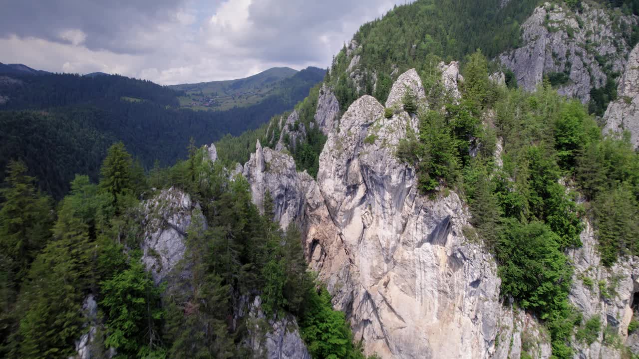 无人机在巨大的岩石之间飞行，揭示了森林山脉的景观视频素材