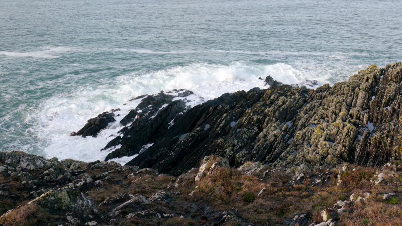 崎岖的海岸线，布满锯齿状的岩石，勇敢地面对海浪的无情冲击。湛蓝的大海形成了令人惊叹的背景。视频素材