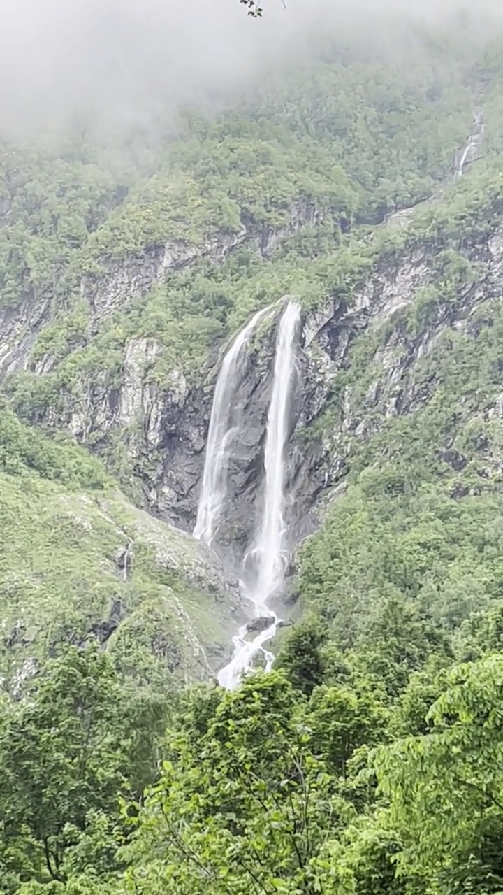 在阳光明媚的夏日漫步在山间，欣赏瀑布。视频素材