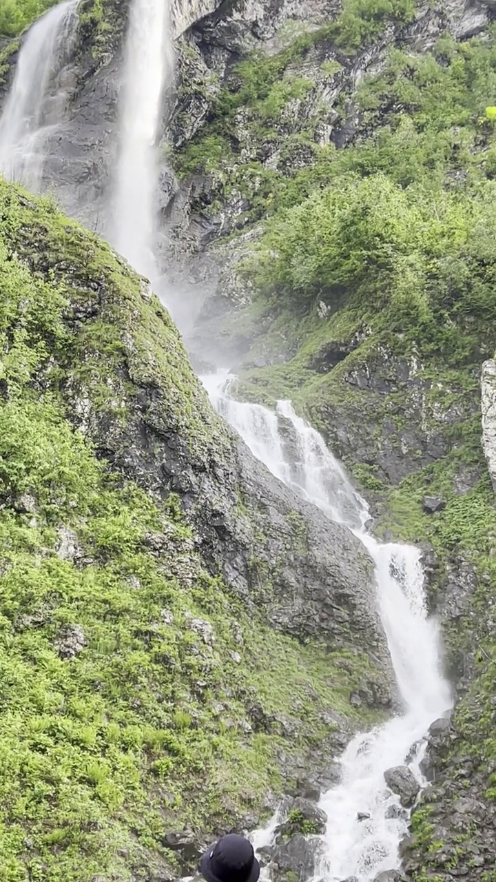 在阳光明媚的夏日漫步在山间，欣赏瀑布。视频素材