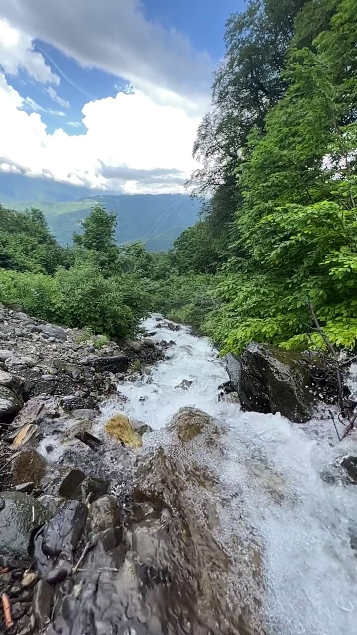 在阳光明媚的夏日漫步在山间，欣赏瀑布。视频素材