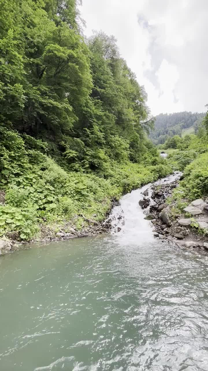 在阳光明媚的夏日漫步在山间，欣赏瀑布。视频下载