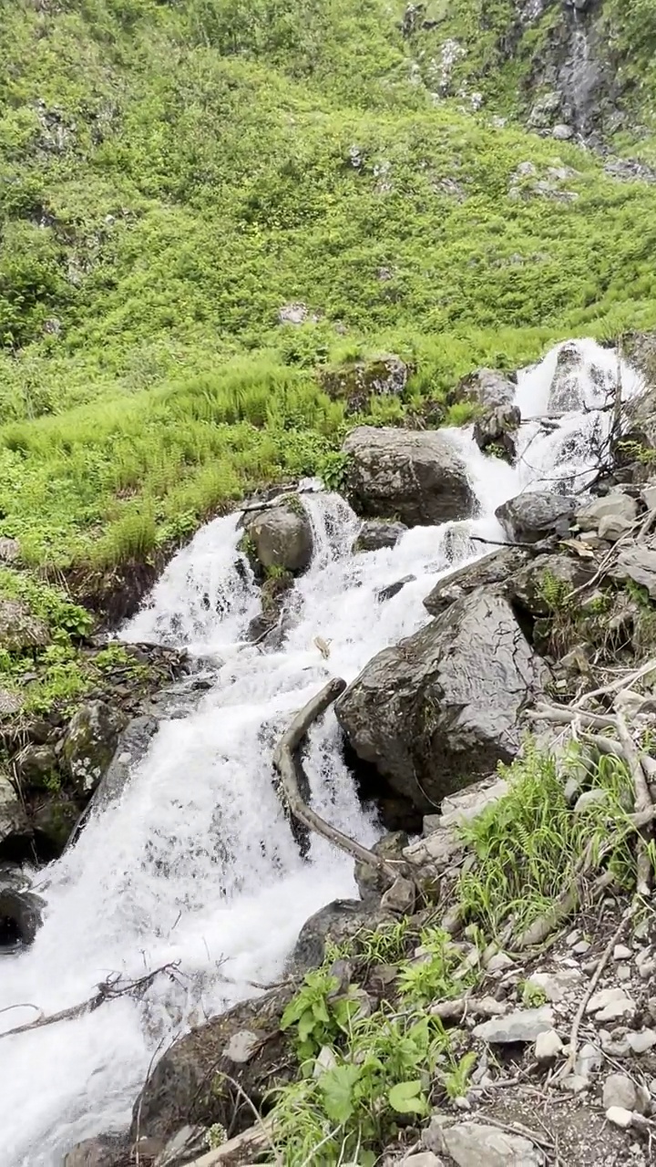 在阳光明媚的夏日漫步在山间，欣赏瀑布。视频素材