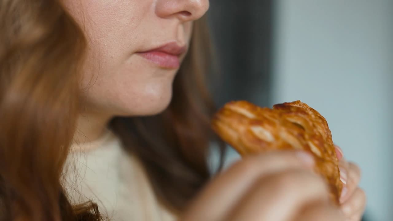 美丽的年轻饥饿的女人在家里厨房的自助餐厅吃着自制的甜点视频素材