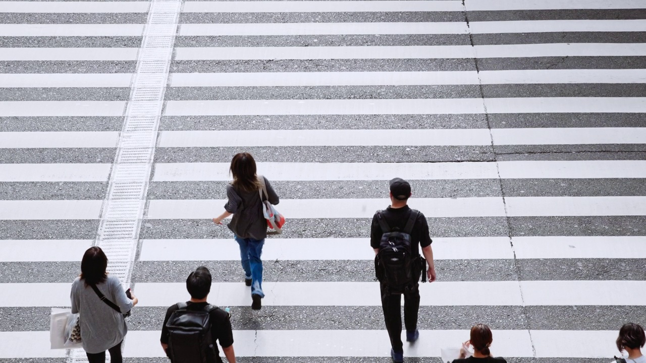 拥挤的日本人，亚洲旅行者走、跑过斑马线。日本文化、东京大阪都市生活方式、亚洲交通、通勤交通或都市生活理念。慢动作视频下载