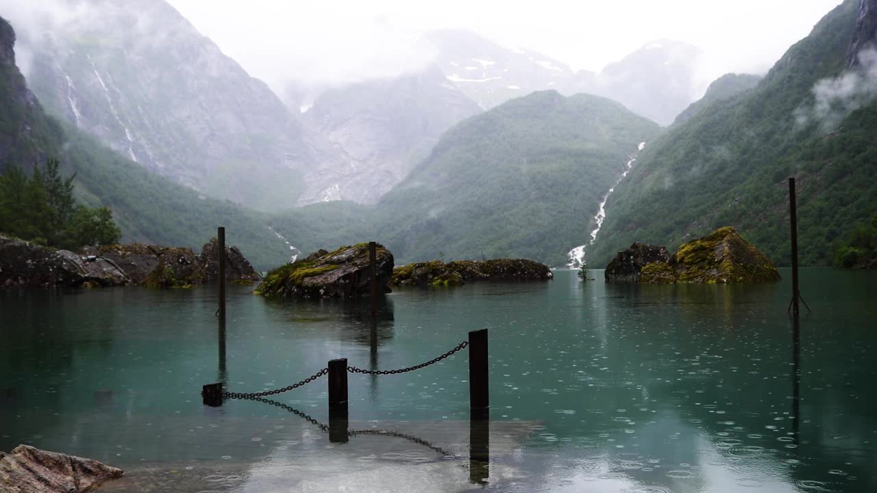 Bondhusvatnet冰川湖被高山和雾蒙蒙的绿色森林环绕，下雨天可以乘船游览挪威。忧郁的日子里的挪威风景。视频素材