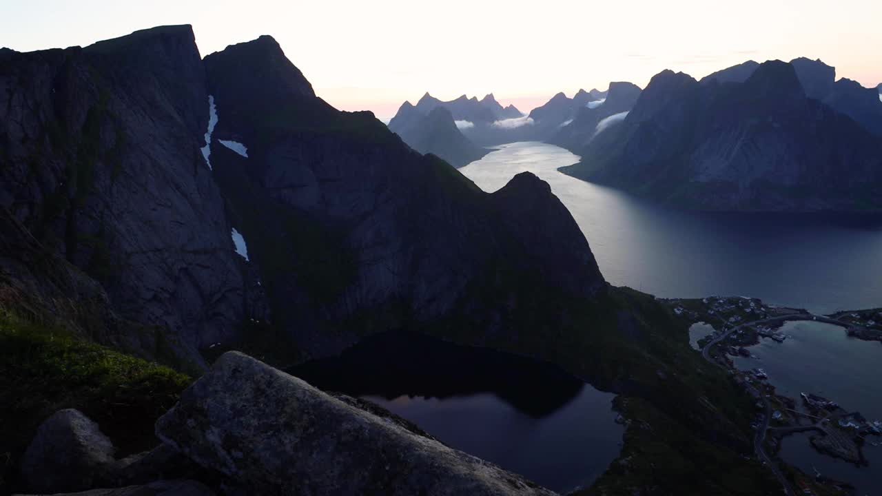 美丽的日落在挪威北部罗弗敦群岛的戏剧性山脉和峡湾-午夜太阳在北极圈视频下载