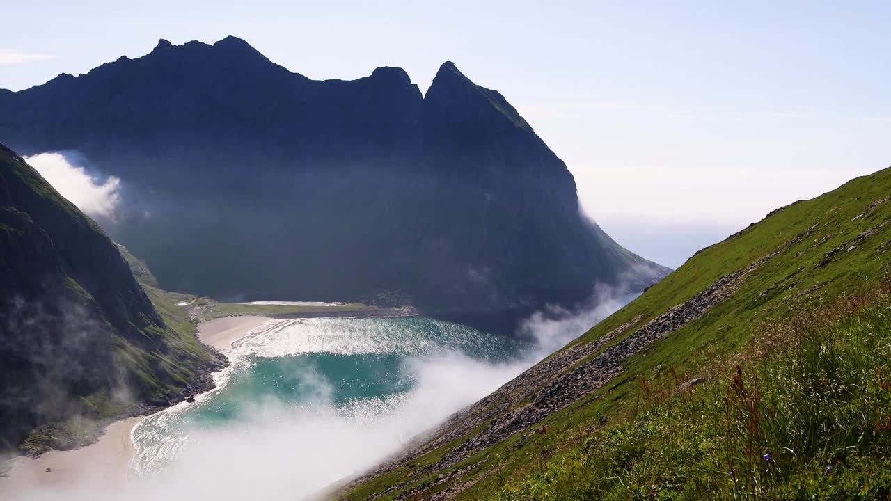 在挪威罗弗敦群岛的Kvalvika海滩，参差不齐的高山、清澈湛蓝的海水和白色的沙滩。北极圈的海滩。视频素材