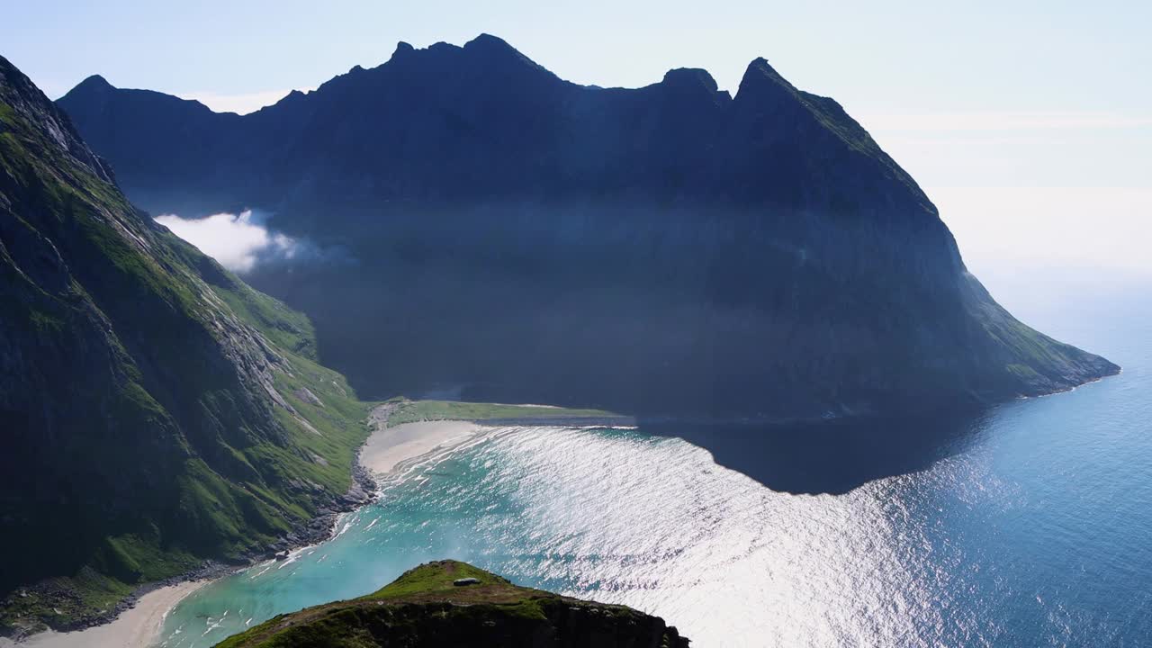 在挪威罗弗敦群岛的Kvalvika海滩，参差不齐的高山、清澈湛蓝的海水和白色的沙滩。北极圈的海滩。视频下载