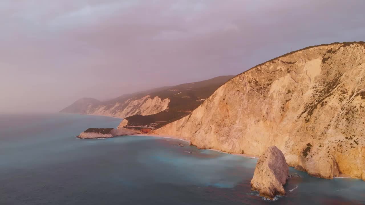 鸟瞰图:美丽的海滩和水湾在希腊壮观的海岸线。日落华丽的天空在蓝色的水独特的岩石悬崖。希腊夏季首选旅游目的地莱夫卡达岛视频下载