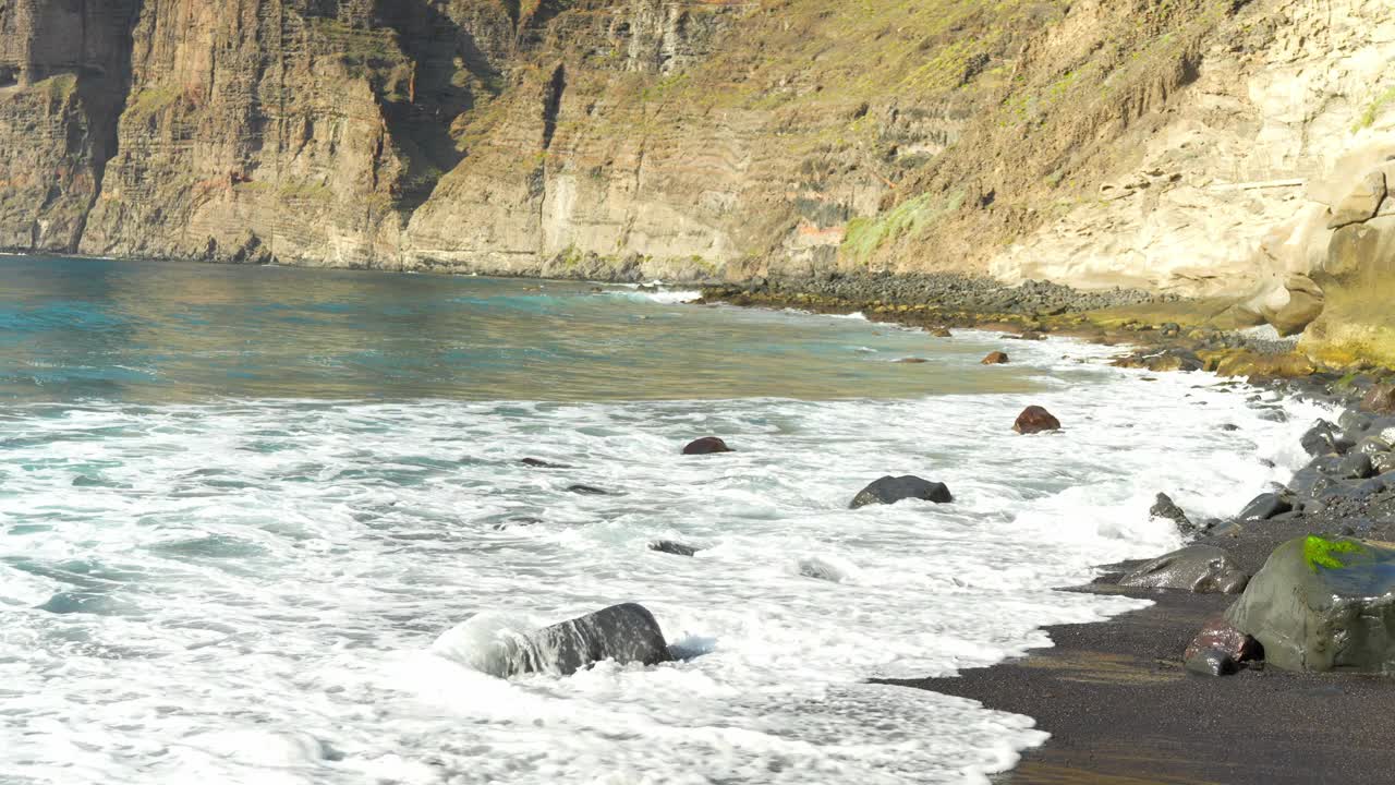 特内里费火山悬崖沿着海岸海湾普拉亚-德-洛斯-奎奥斯与蓝色的海浪。视频素材