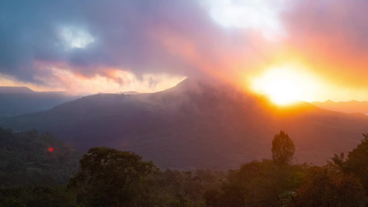 印度尼西亚巴厘岛金塔马尼的巴图尔火山上的彩色日出与雾云的时间延迟。视频素材