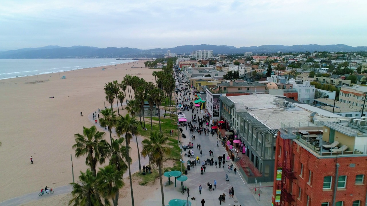 从空中向下拍摄的人们在海滩上的城市建筑物对着天空-洛杉矶，加利福尼亚视频素材