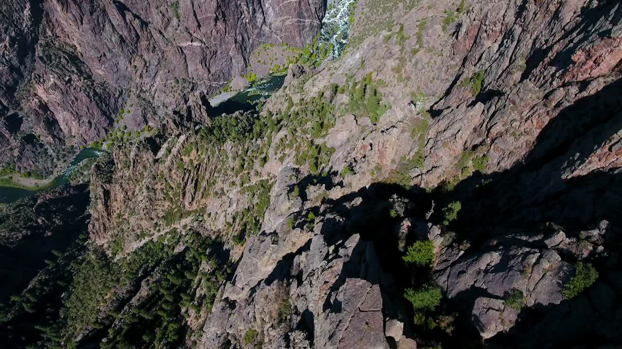 空中向后倾斜拍摄的河流在山谷附近的山脉对蓝天-冠丘，科罗拉多州视频素材