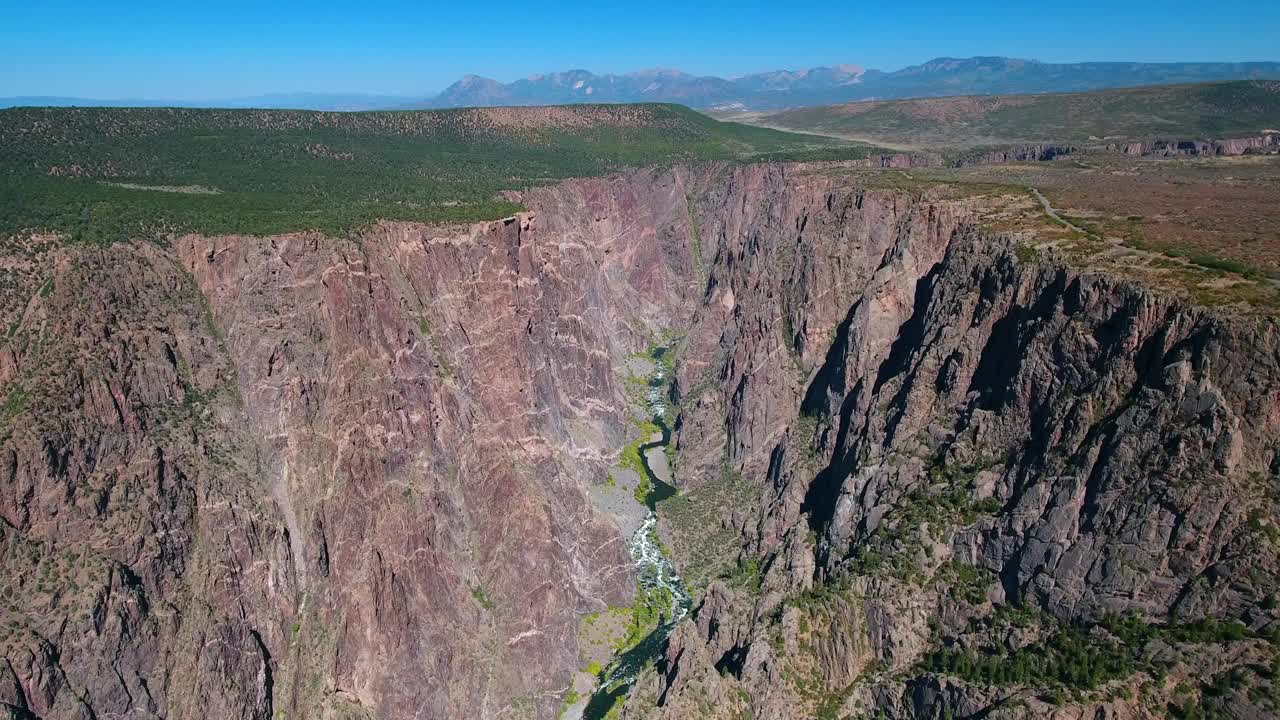 空中平移拍摄的河流在山谷附近的山脉对蓝天-冠丘，科罗拉多州视频素材