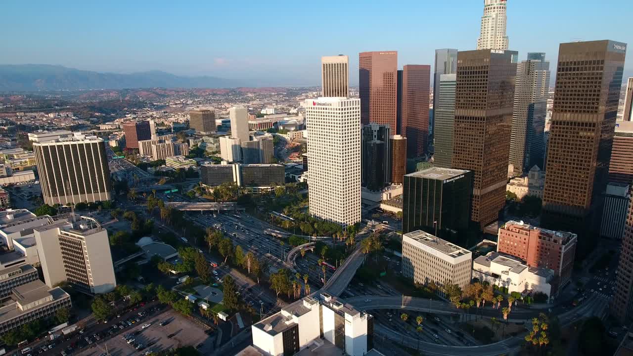 空中拍摄的市区和摩天大楼在道路上的车辆在城市对天空-洛杉矶，加利福尼亚视频素材