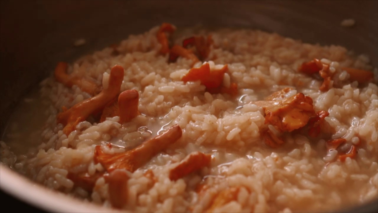 厨师正在准备意式蘑菇烩饭(意式蘑菇烩饭)，同时加入清汤视频素材