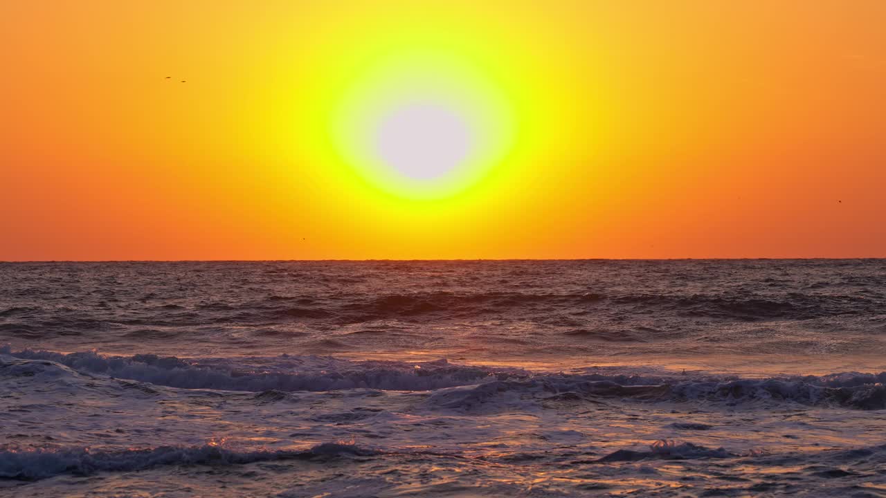 海洋的日出在海滩、海岸和波浪上。太阳从地平线上冉冉升起视频素材