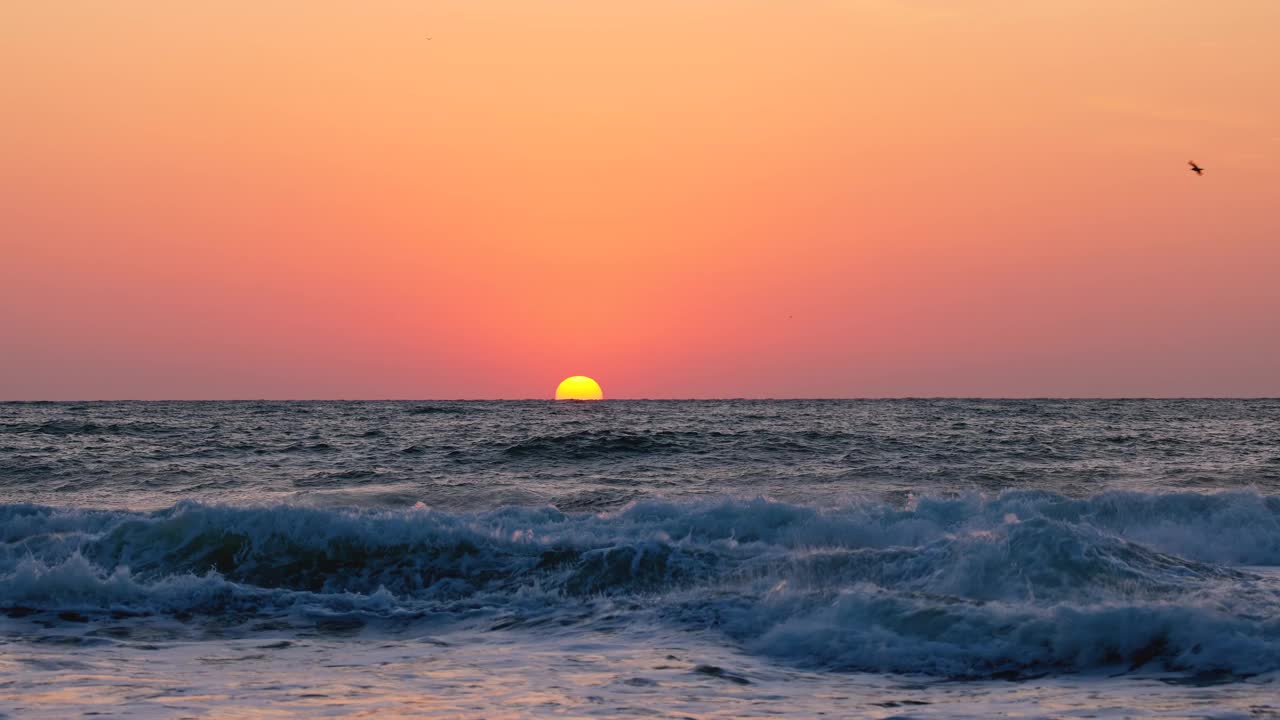 海洋的日出在海滩、海岸和波浪上。太阳从地平线上冉冉升起视频素材