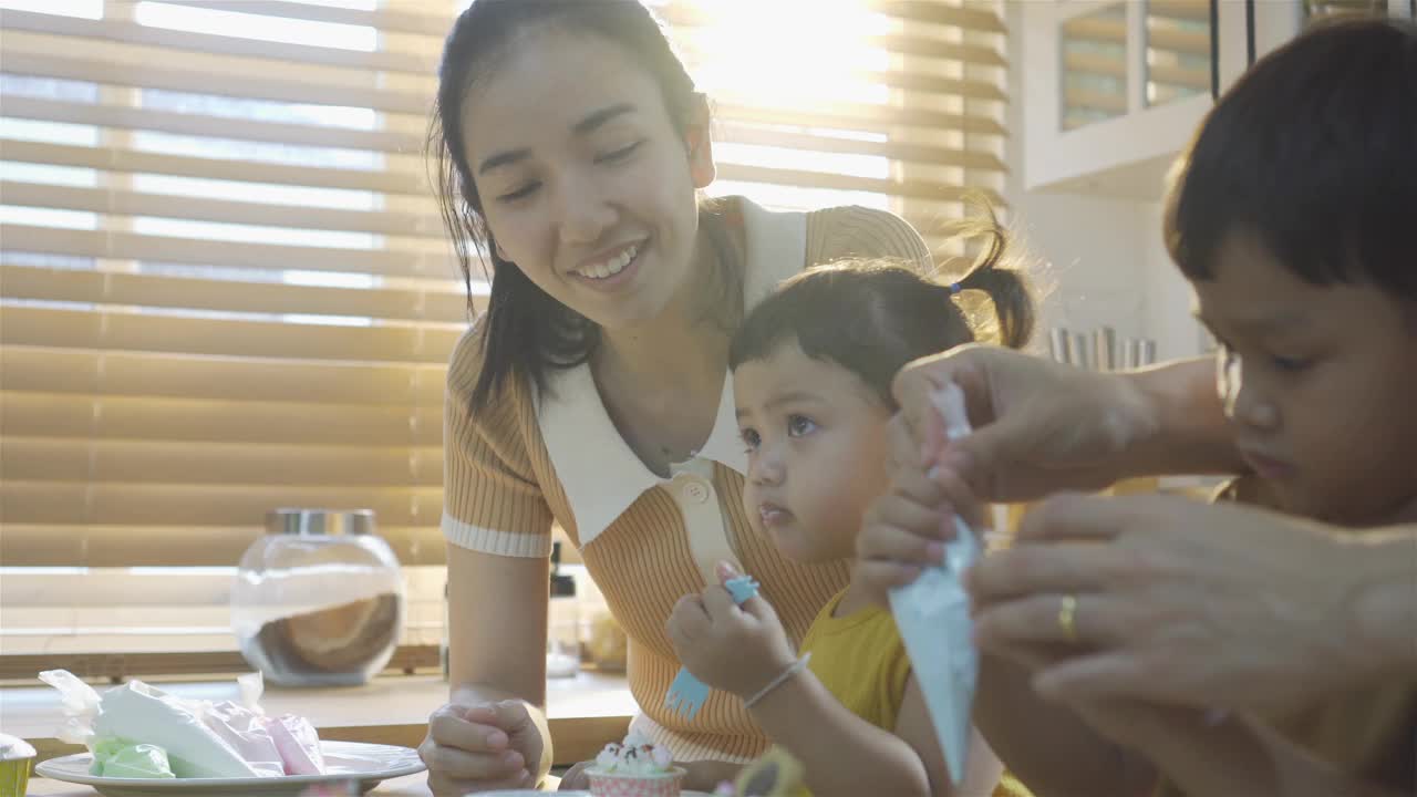 小男孩和小女孩和妈妈在厨房准备生日蛋糕视频下载