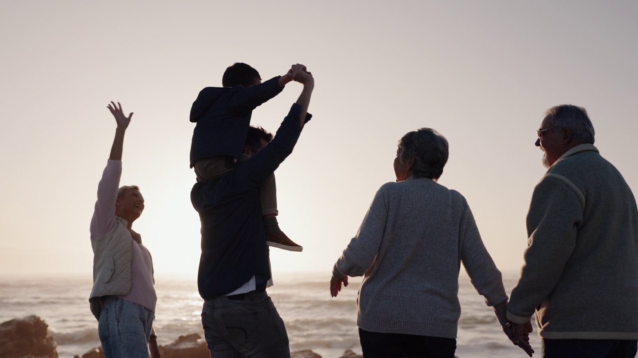 幸福的家庭，手牵着手或祖父母在海滩夕阳放松与爱或关心假日假期。爸爸，妈妈或孩子的背后与祖母或祖父在海上欣赏海景视频素材