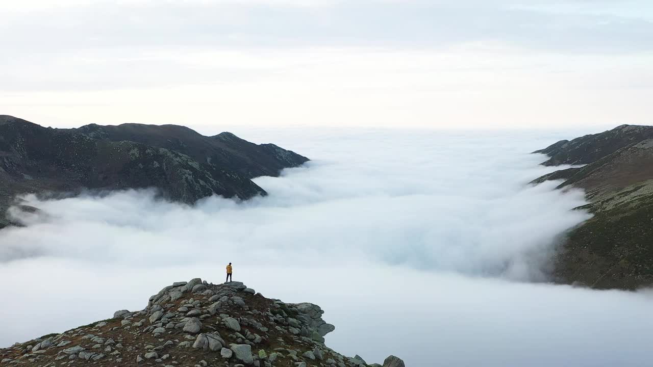 穿黄色外套的人看着独特的景色Altıparmak山伴着云。无人机的观点。街头舞魂,土耳其。视频素材