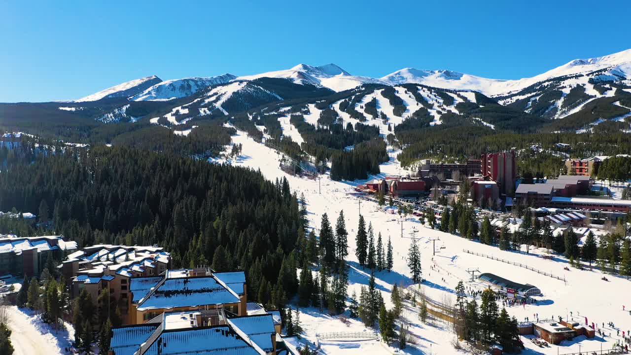 科罗拉多州布雷肯里奇的滑雪度假村酒店，冬季户外森林中山脉和积雪覆盖的小径的空中无人机视图视频素材