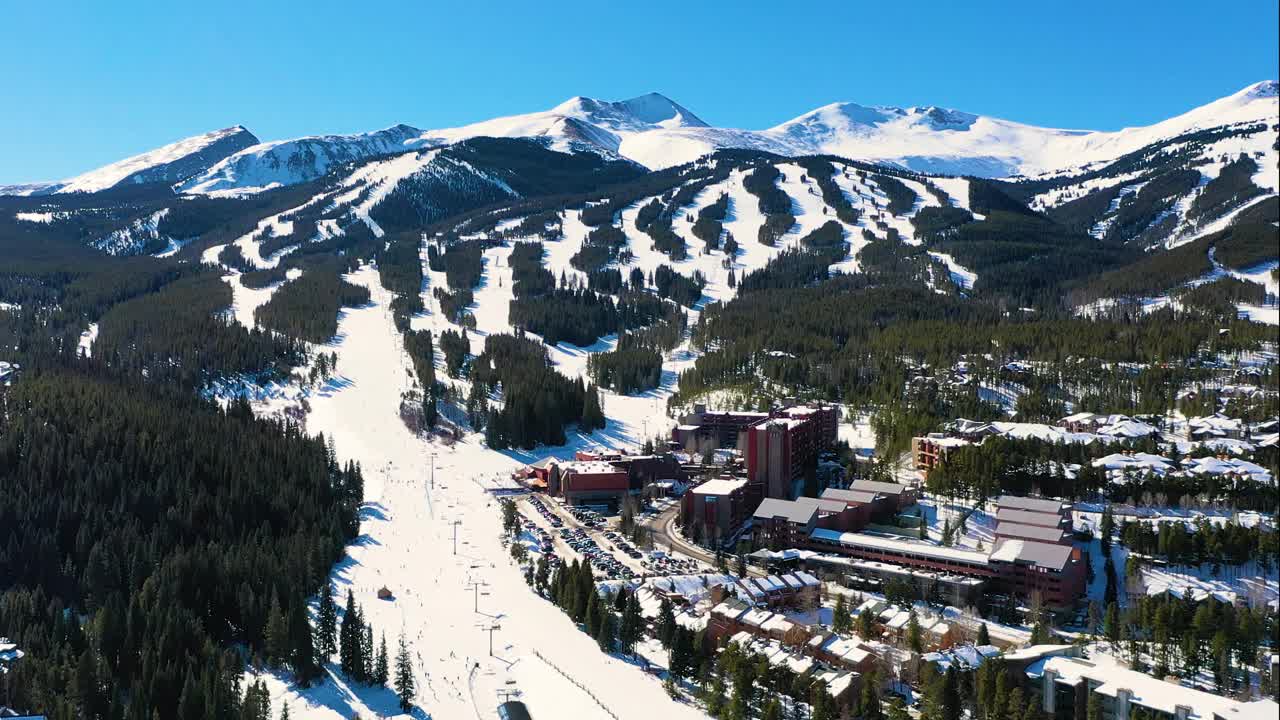 布雷肯里奇，科罗拉多州空中无人机观看滑雪斜坡与缆车和城镇与山区住宅和度假租赁视频素材