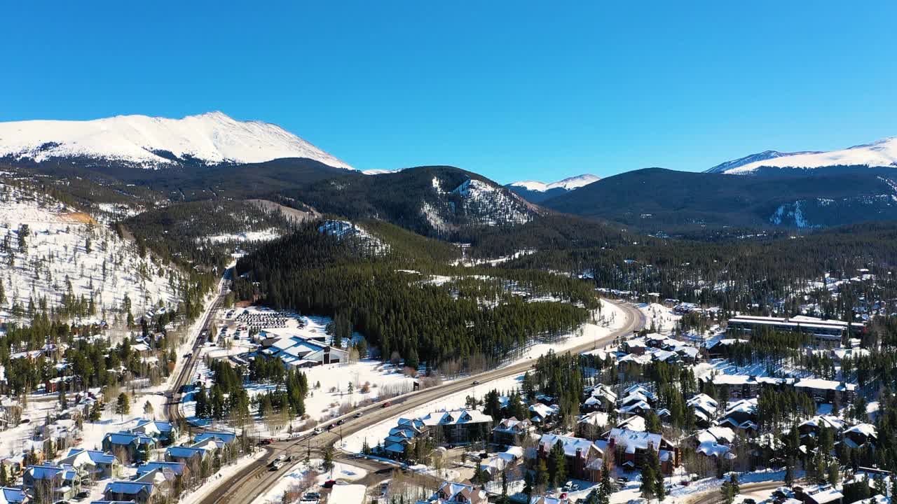 华丽的布雷肯里奇科罗拉多山城，白雪覆盖的房屋和人们在松树林的道路上开车，无人机视图视频素材