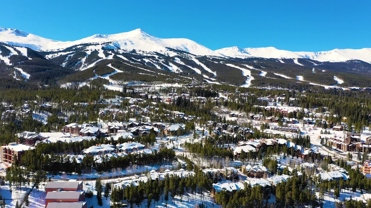 科罗拉多州布雷肯里奇上空的无人机。整个小镇和滑雪场都被雪覆盖，四周都是松树。空中视频素材