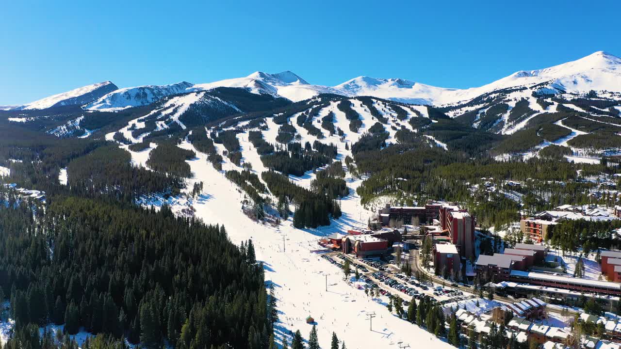 空中无人机俯瞰滑雪斜坡与缆车俯瞰美丽的山峰在布雷肯里奇科罗拉多州与山的房子和度假租赁视频素材