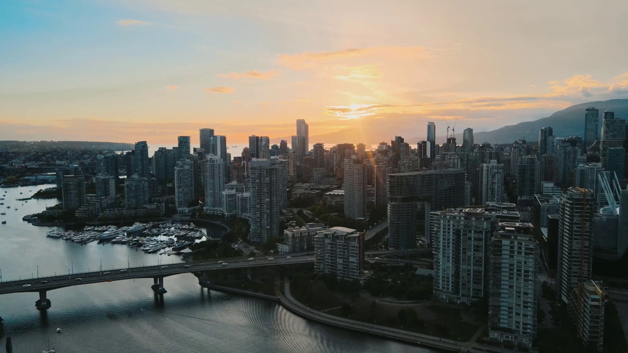 日落时分，温哥华岛的市区、摩天大楼和桥上的汽车在空中拍摄视频素材