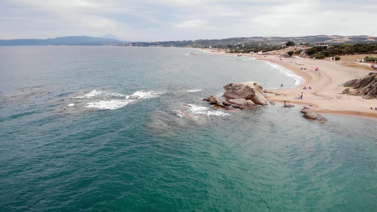 无人机视频下降海浪冲击海洋岩层显示沙滩海岸线视频素材