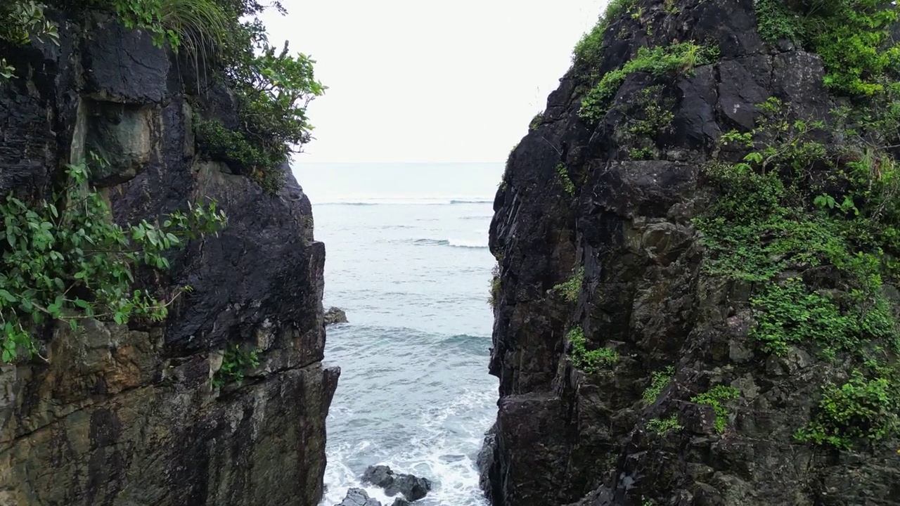 高耸的海岸岩石的电影空中天桥，揭示了令人惊叹的海洋礁波在巴拉斯，卡坦多内斯。视频素材