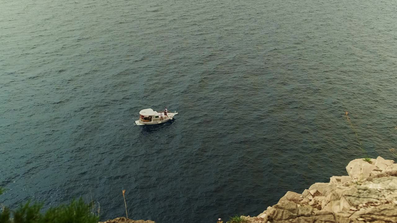 船在蓝色的大海上航行。高高的悬崖和高山。美丽的风景。波浪上的船。荒岛上视频素材