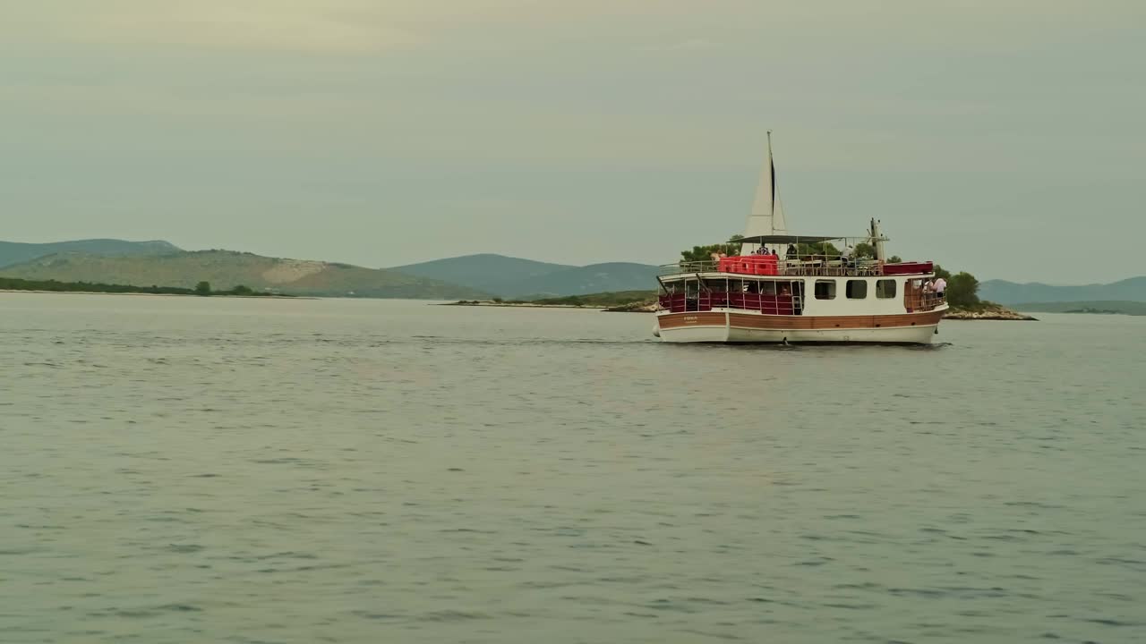 船在蓝色的大海上航行。高高的悬崖和高山。美丽的风景。波浪上的船。荒岛上视频下载