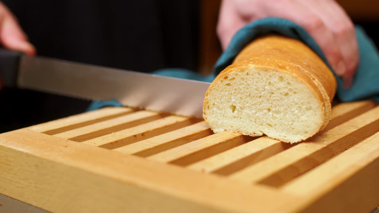 刚烤好的面包框，切在木板上。一块面包，一块食物，健康饮食理念。视频素材