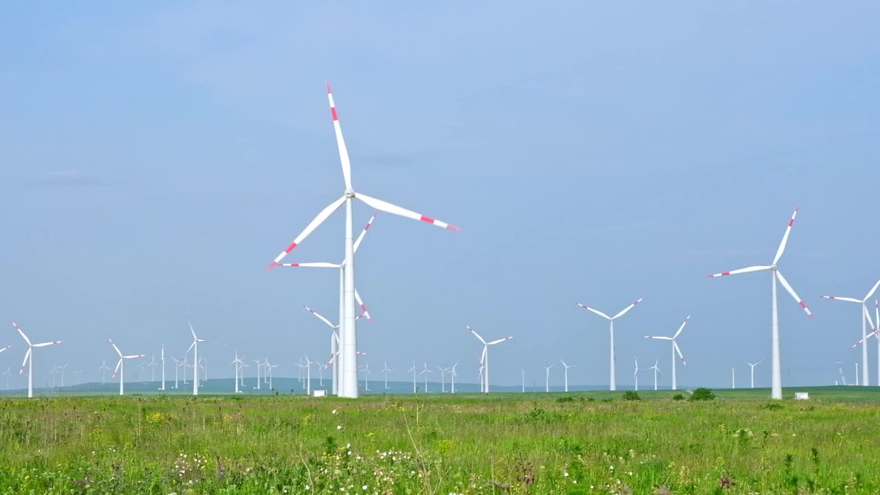 夏日的风力涡轮机和农田。利用可再生能源生产能源视频下载