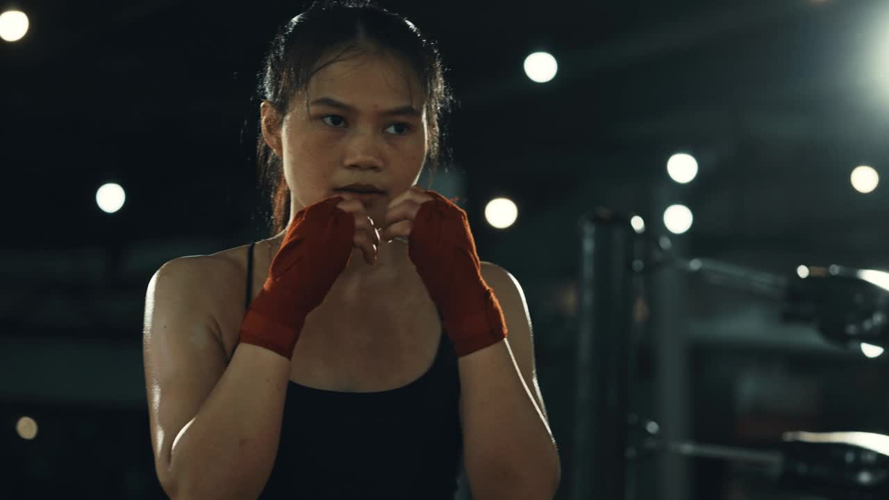 女拳击手在拳击馆里训练出拳，快速训练一系列出拳。视频下载