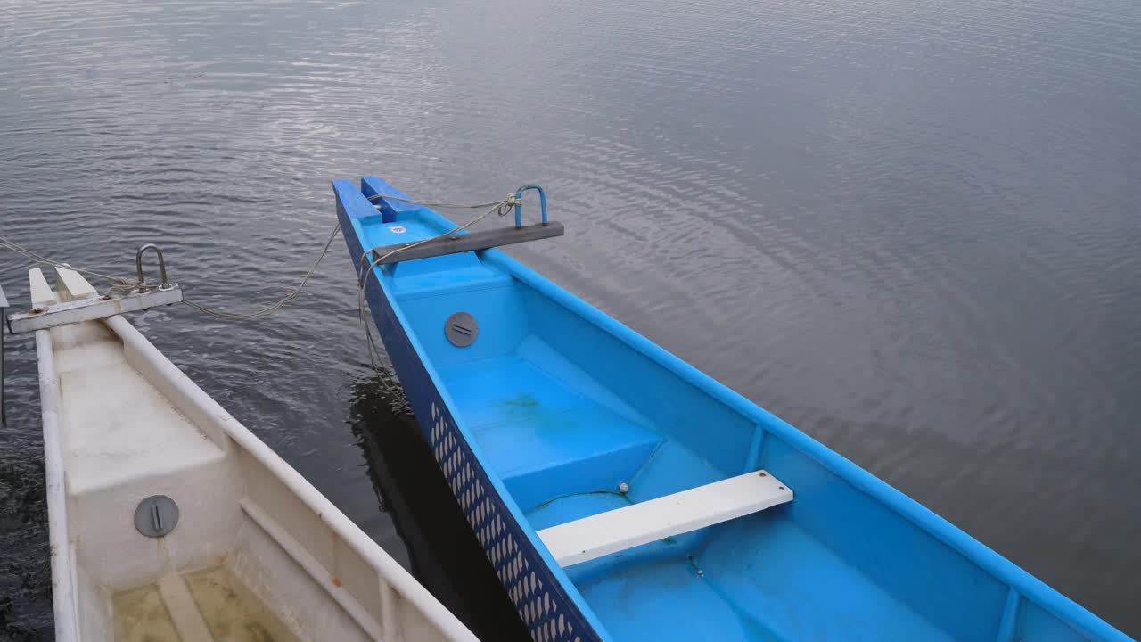 蓝色木船鼻子在湖与波浪水的背景视频下载