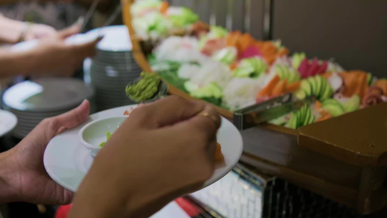 人们在酒店餐厅里抢日式自助餐生鱼片视频素材