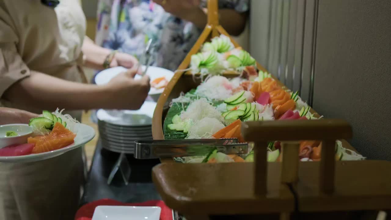 人们在酒店餐厅里抢日式自助餐生鱼片视频素材