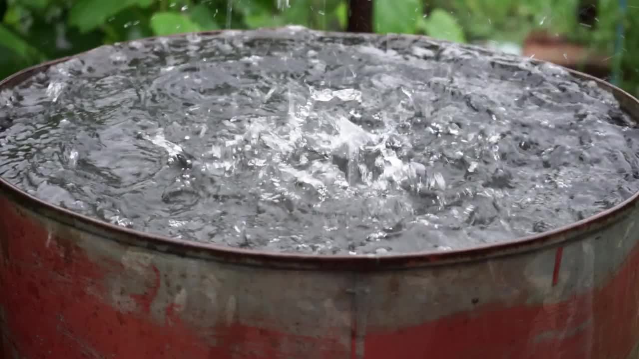 雨水从屋顶流入桶中视频素材